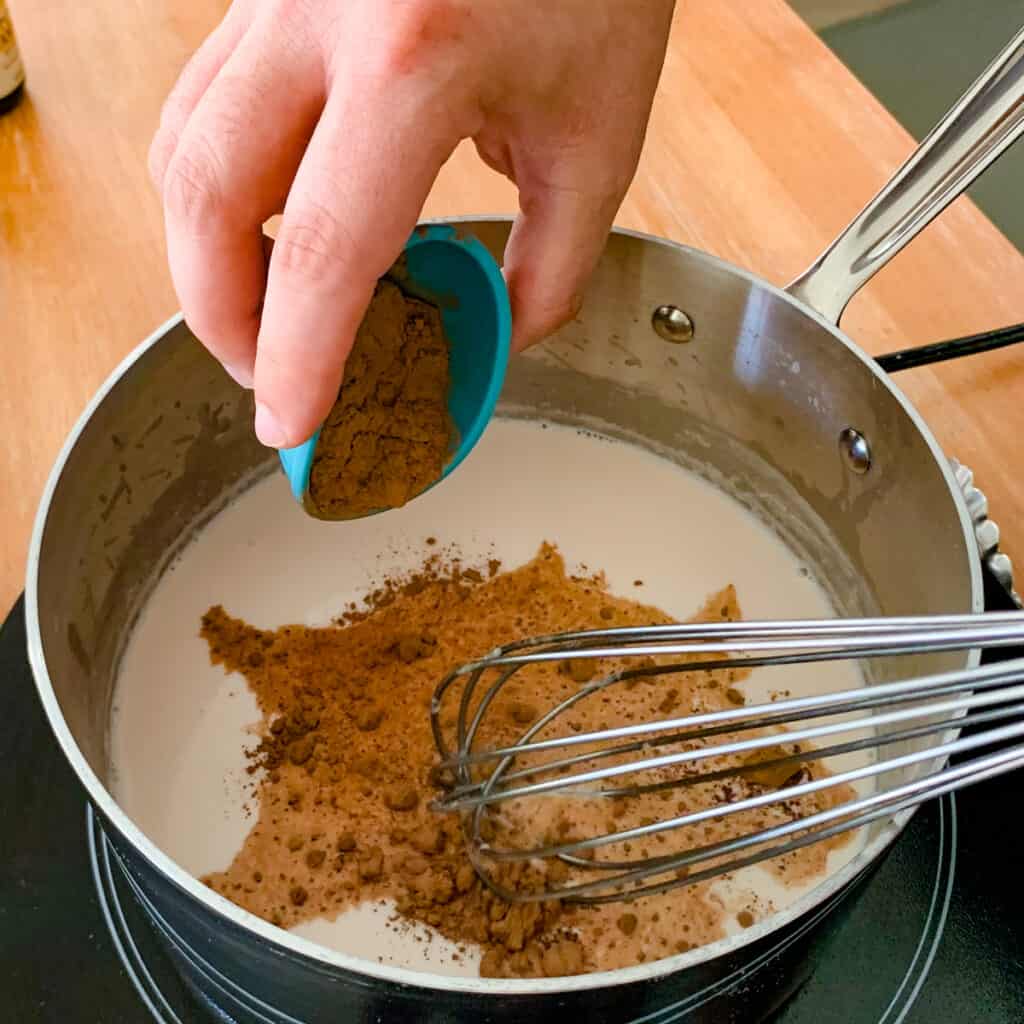Adding cocoa powder to steamed milk